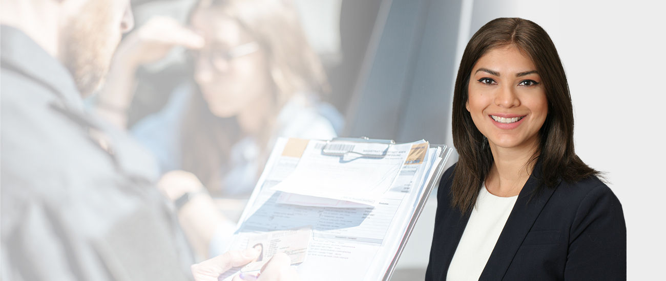 A professional woman in a business suit confidently holds a piece of paper, exuding competence and professionalism.